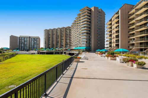 a walkway with umbrellas and tables and buildings at Sea Colony---1805 Doubles Court in Bethany Beach