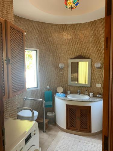 a bathroom with a sink and a mirror at Villa Jardines la Quinta in El Paso