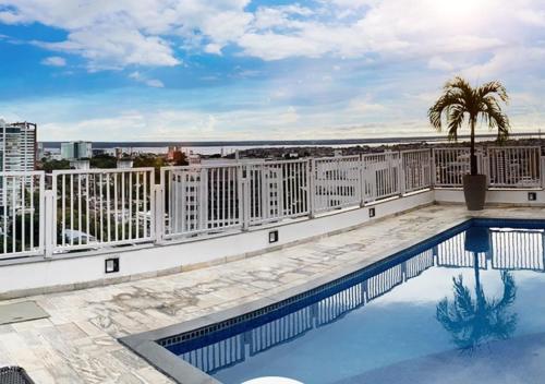 a swimming pool on the roof of a building at Hotel Adrianópolis All Suites in Manaus