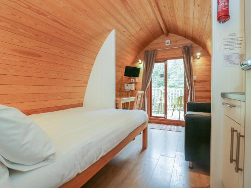 a bed in a room with a wooden ceiling at Pod No 6 in Keswick