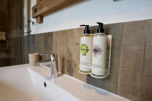 two bottles of soap are on a bathroom sink at Tring Grange Cottage in Wigginton