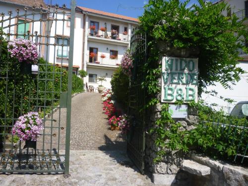a sign on the side of a fence with flowers at Nido Verde in Agerola
