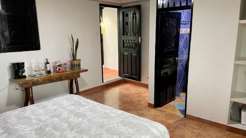 a room with a bed and a black door at Aguas Claras Luxury Hospedaje in Filandia