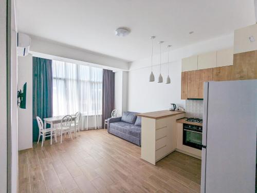 a kitchen and living room with a couch and a table at Brand new apartment in Kutaisi in Kutaisi