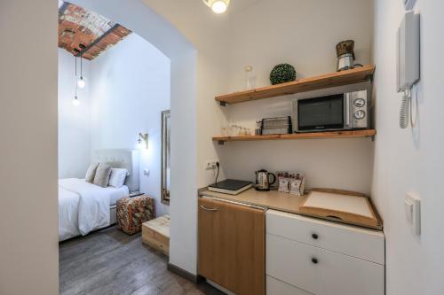 a kitchen with a counter with a microwave and a bed at Puerta del Sol Apartamento economico in Madrid