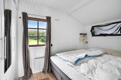 een bed in een kamer met een raam bij Cozy Beach House In Northern Part Of Seeland in Vejby