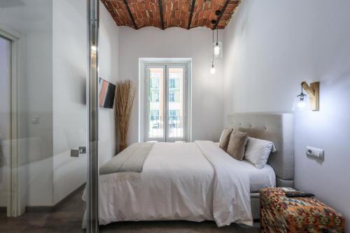 a white bedroom with a bed and a window at Puerta del Sol Apartamento economico in Madrid