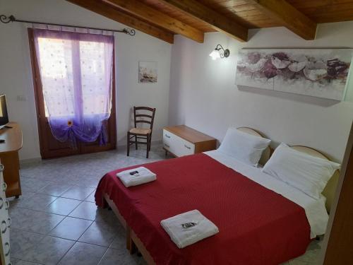 1 dormitorio con 1 cama grande con manta roja en B&B da Marianna en Samughèo