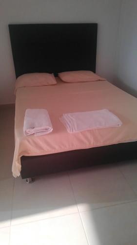 a bed with pink sheets and two towels on it at APARTA ESTUDIO NUEVO in Socorro