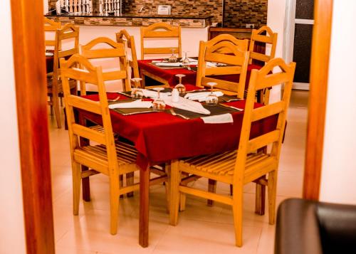a dining room table and chairs with a red table cloth at Randa Cottages Moshi in Kirua