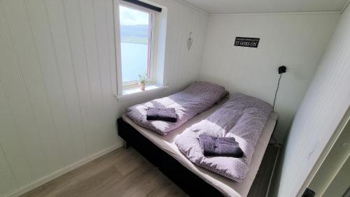 Habitación pequeña con 2 camas y toallas púrpuras en The Cozy red house with Amazing sea view 