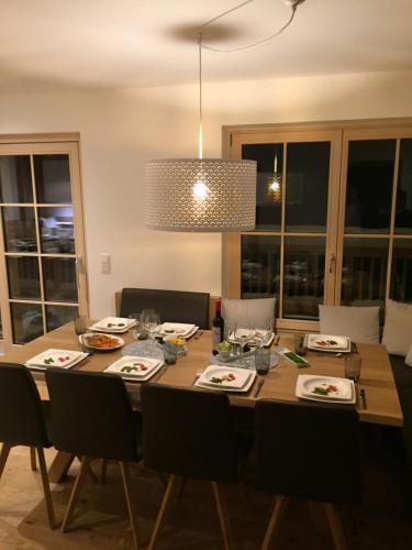 uma mesa de jantar com cadeiras e um candeeiro em Soul Mountain Lodge em Mühlbach am Hochkönig