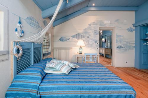 a bedroom with a bed with a blue comforter at Segnavento -Rooms and Suites- in Manta
