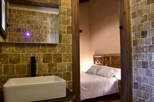uma casa de banho com um lavatório e uma cama num quarto em La Casa del Guarda - Turismo Sotosalbos em Sotosalbos