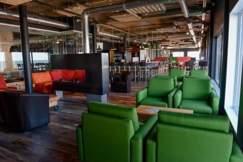 a large room with green chairs and a fire place at Riotel Matane in Matane