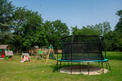 a playground with a black basket in the grass at Gîtes sympa, prés du zoo de beauval, "Au Havre de Paix" in Couffy