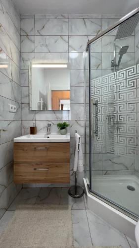 a bathroom with a shower and a sink and a tub at The Nest in Floreşti