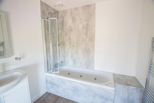 uma casa de banho com uma banheira e um lavatório em Poseidon Inn em Lossiemouth