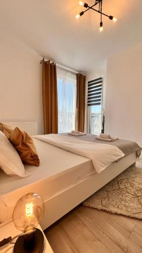a large white bed in a room with a window at The Nest in Floreşti