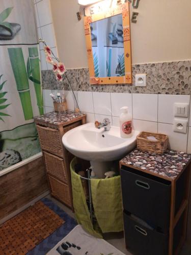 La salle de bains est pourvue d'un lavabo et d'un miroir. dans l'établissement Au Bonheur des enfants, à Ibos