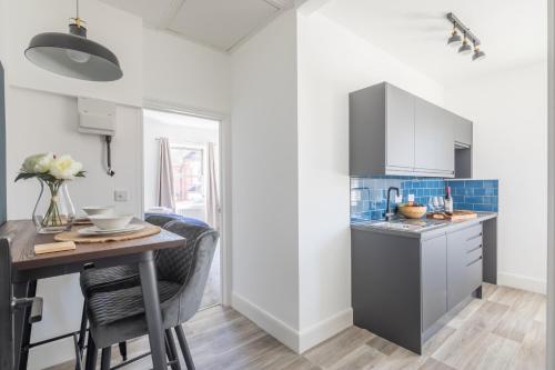 a kitchen with a wooden table and a counter top at Radcliffe Studios in Wolverton