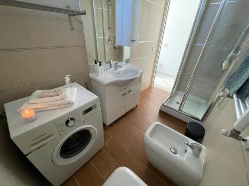 ein Badezimmer mit einer Waschmaschine und einem Waschbecken in der Unterkunft The Sea House in Fiumicino