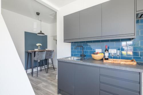 a kitchen with blue tiles and a counter top at Radcliffe Studios in Wolverton