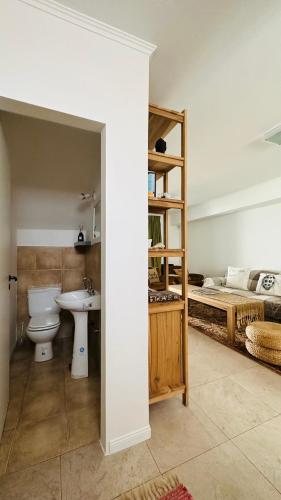 a bathroom with a toilet and a sink and a bed at Bragado Siempre 247 in Bragado