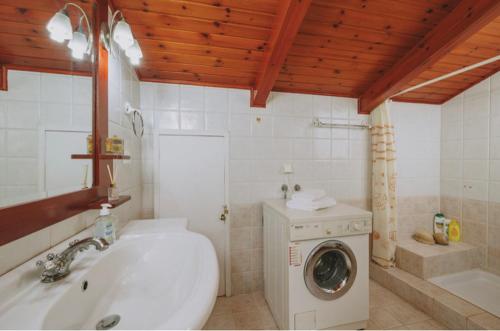 y baño con lavabo y lavadora. en Sofita, en Arménoi
