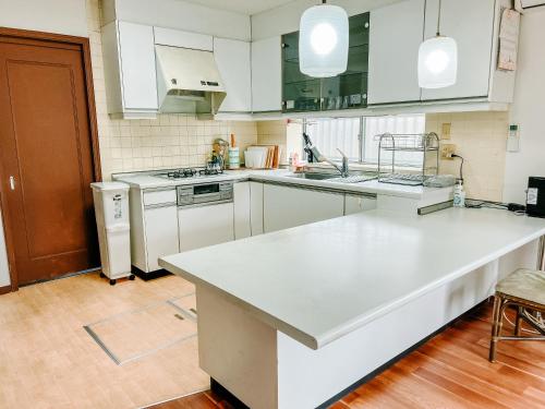a kitchen with white cabinets and a white counter top at シテコベハウス in Yokosuka