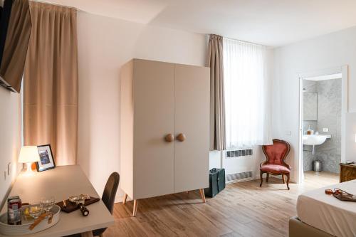 a room with a white cabinet and a table and a chair at Villa Tosati in Monza