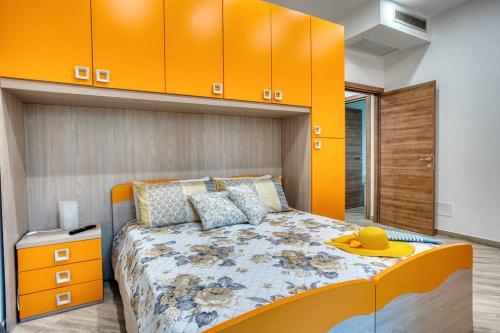 een slaapkamer met een bed met een oranje muur bij Margaret House Sorrento in Sorrento