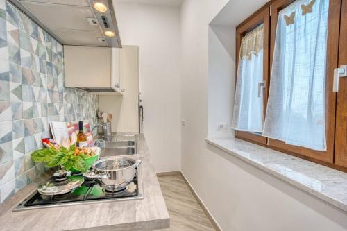 een keuken met een aanrecht met een wastafel en een raam bij Margaret House Sorrento in Sorrento