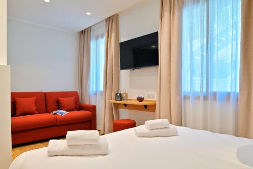 une chambre d'hôtel avec deux lits et un canapé rouge dans l'établissement HOTEL SAINT ROCH, 