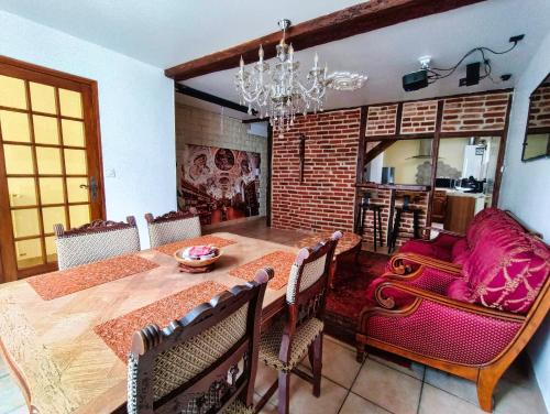 une salle à manger avec une table en bois et un mur en briques dans l'établissement Maison Royale - Idéalement située à Blois, à Blois