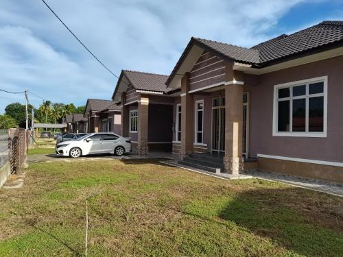 a house with a car parked in the driveway at FIYA ViLA HOMESTAY in Ketereh
