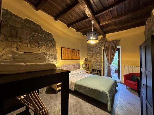 1 dormitorio con cama y pared de piedra en Al Cardinale, en Viterbo