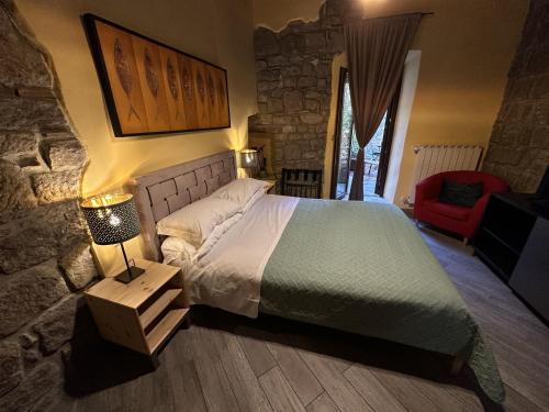 a bedroom with a large bed and a red chair at Al Cardinale in Viterbo