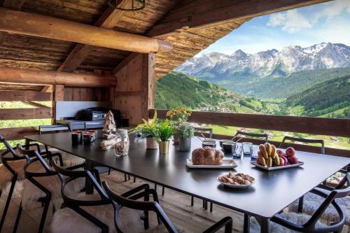 a table in a room with a view of mountains at Chalet Happyview - OVO Network in Le Grand-Bornand