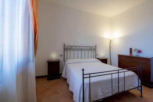 ein Schlafzimmer mit einem Bett, einer Kommode und einer Lampe in der Unterkunft Appartamenti immersi nelle colline Toscane in Molino Mazzetti