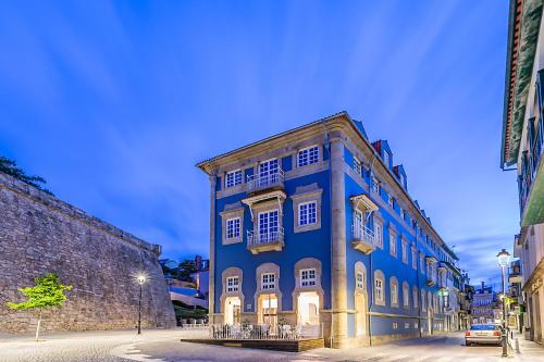 a blue building with white windows on a street at ibis Styles Chaves in Chaves