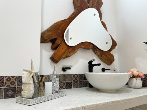 a kitchen counter with a white sink and a wooden sculpture at Aguas Claras Luxury Hospedaje in Filandia