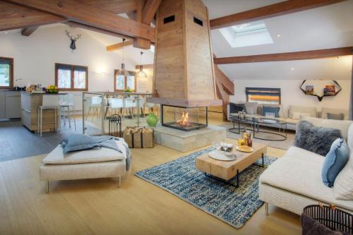 a large living room with a fireplace and a kitchen at Chalet Riparian - OVO Network in La Clusaz