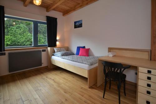a small bedroom with a bed and a desk and a table at Farma Noe in Březina