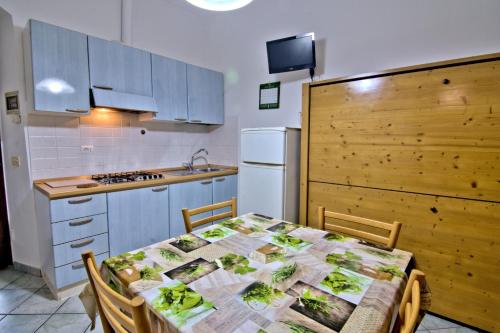 a kitchen with a table and a kitchen with a refrigerator at Villa Very in Marina di Campo