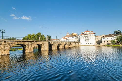 a bridge over a river with buildings in the background at ibis Styles Chaves in Chaves