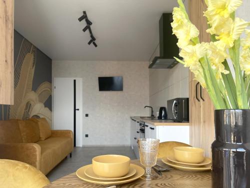 a living room with a table with yellow flowers on it at Апартаменти Еліт, Центр, ЖК Яровиця, Паркомісце in Luts'k