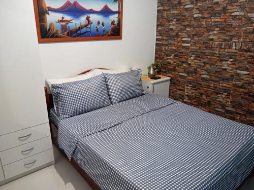 a bedroom with a bed with a blue and white checked comforter at Yafe Nof 35 in Ashqelon