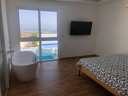 1 dormitorio con bañera y vistas a la piscina en Gezellige villa met prachtig zicht en zwembad en Arona