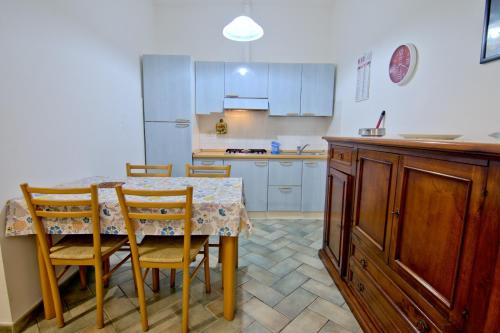 a kitchen with a table and chairs and a kitchen with white cabinets at Villa Very in Marina di Campo